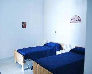 Dos camas en una habitación con sábanas azules. en Casa della Luna, en Amalfi