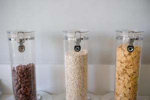 three glass containers filled with oats and nuts on a counter at Decanting Porto House in Porto
