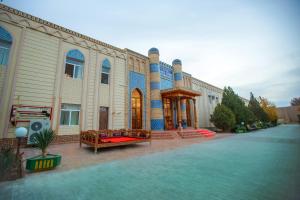 un gran edificio con un banco delante en QiBLA TOZABOG, en Khiva