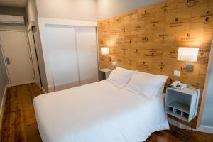波多的住宿－迪坎汀波爾圖酒店，卧室配有白色的床和电话