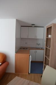 een keuken met witte kasten en een witte koelkast bij House Marija in Brela +11 foto's