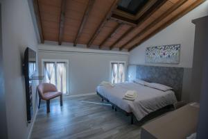 ein Schlafzimmer mit einem Bett und einem Stuhl in der Unterkunft Lanterna Room&Breakfast in Carpi