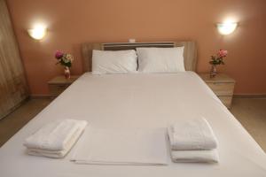 ルツァにあるSelini hotelの大きな白いベッド(タオル2枚付)