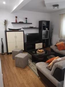a living room with two couches and a tv at Apartman Roza in Ploče