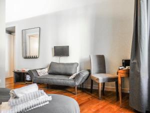 a living room with a couch and two chairs at Mecenate Rooms in Rome