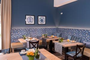 ein Esszimmer mit blauen Wänden, Tischen und Stühlen in der Unterkunft Visbeker Deern Hotel Garni in Visbek