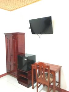 escritorio con TV y mesa de madera con silla en Hotel Los Higuerones, en Canoas