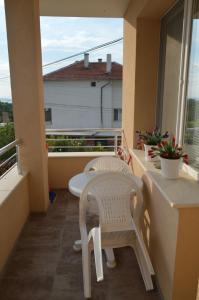 a balcony with two white chairs and a table at Yanis in Chernomorets