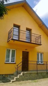 a yellow house with two balconies on it at NOCLEGI U STASI in Cisna