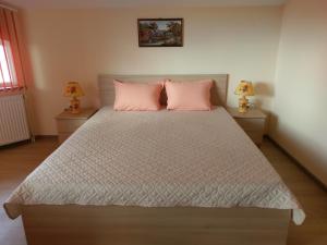 - une chambre avec un grand lit et des oreillers roses dans l'établissement Стаи за гости Елени, à Shiroki Dol