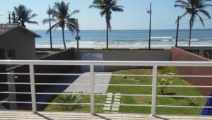 a view of a beach with palm trees and the ocean at Casa temporada in Mongaguá