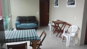 a living room with a couch and a table and chairs at Casa temporada in Mongaguá