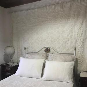 a bedroom with a white bed with two white pillows at Casa de Chanca in Penela