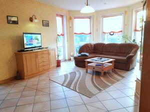 a living room with a couch and a tv at Feriendomizil am Hafen in Zingst