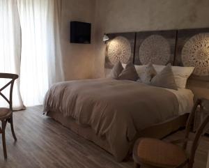 a bedroom with a large bed and a tv on the wall at Hotel Silva in Alberobello