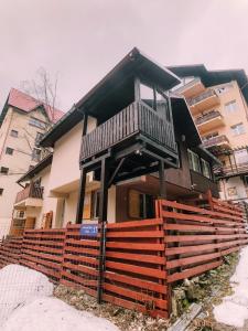 a house with a wooden fence in front of it at Spacious Apartment near Peles in Sinaia