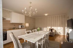Vacation house Artorius في ليوبليانا: مطبخ وغرفة طعام مع طاولة وكراسي بيضاء