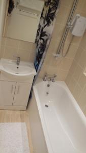 a bathroom with a sink and a bath tub and a sink at Hastings Pad in Hastings