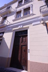 un edificio bianco con una porta in legno di Apartamentos Dormavalencia a Valencia