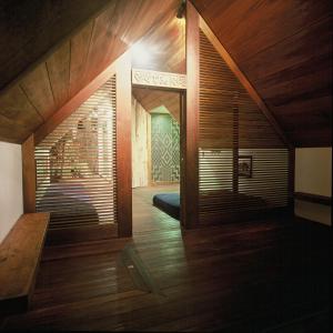 Lake Tarawera的住宿－te Whare -Lake Tarawera tree-top nest，一座房子,拥有木墙和木地板
