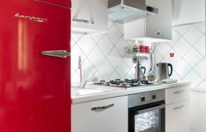 - un réfrigérateur rouge dans la cuisine avec évier dans l'établissement Studioflat University, in centro a Bologna, à Bologne