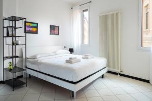 - une chambre blanche avec un lit et des serviettes dans l'établissement Studioflat University, in centro a Bologna, à Bologne