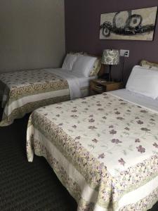 A bed or beds in a room at Restland Motel