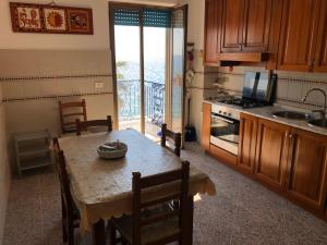 a kitchen with a table and a kitchen with a balcony at Locazione Turistica F.G. Rando in Letojanni