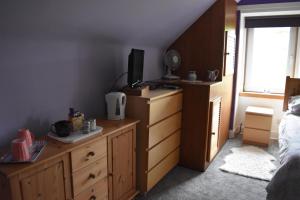 1 dormitorio con 1 cama y vestidor con TV en Bridgehill Cottage Bed & Breakfast, en Crieff