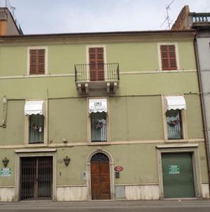 zielony budynek z balkonem na ulicy w obiekcie B&B Vittorio Emanuele w mieście San Benedetto del Tronto