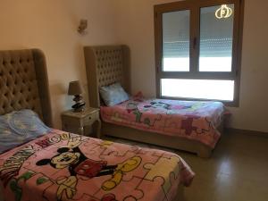 sypialnia z 2 łóżkami i pościelą powitalną w obiekcie Immeuble l'Espadon w mieście Mahdia