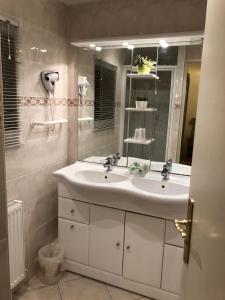 a bathroom with a white sink and a mirror at La Ferme de la Place in Bouvines