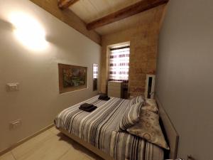 ein Schlafzimmer mit einem Bett in der Ecke eines Zimmers in der Unterkunft Great Siege Apartment in Senglea