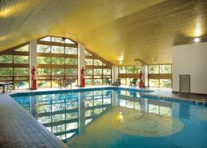 a large swimming pool in a large building at Tiggywinkle Beck Lodge in Windermere