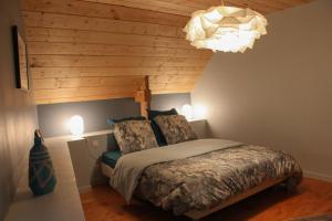 a bedroom with a bed and a chandelier at Gites du Hérisson in Bégard