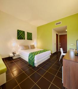AlbaniaにあるHotel Waya Guajiraのベッドとデスクが備わるホテルルームです。