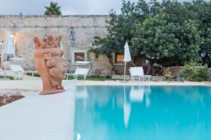 a statue sitting next to a swimming pool at Terre di Cavalusi Relais in Donnafugata