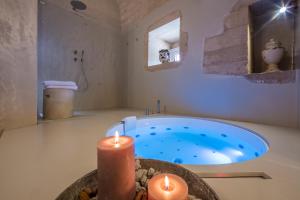 a bathroom with a tub with two candles in it at Terre di Cavalusi Relais in Donnafugata