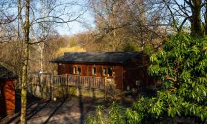 a small house with a balcony in the woods at Owls House, White Cross Bay, Ambleside, Windermere in High Wray