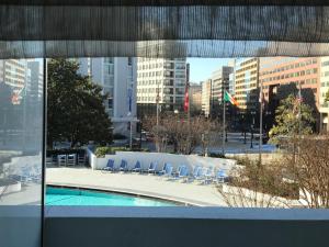 uma vista para uma piscina com cadeiras e edifícios em Washington Plaza Hotel em Washington