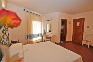a bedroom with a bed and a desk and a window at Hotel Il Piccolo Golf in Porto Cervo