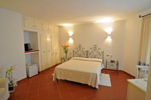 a bedroom with a bed and flowers in a room at Hotel Il Piccolo Golf in Porto Cervo