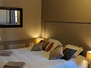 1 dormitorio con 1 cama blanca grande con almohadas en Loge Montaigne, en LʼHôpital-sous-Rochefort