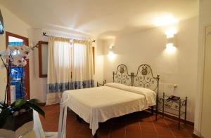 a bedroom with a white bed and a window at Hotel Il Piccolo Golf in Porto Cervo