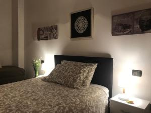 een slaapkamer met een bed en twee foto's aan de muur bij Kibilù - Via Falcone - City Centre - Duomo in Milaan