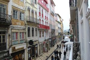 eine Gruppe von Menschen, die eine Straße mit Gebäuden entlang gehen in der Unterkunft Main Street Maison in Coimbra