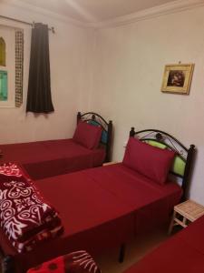 2 camas en una habitación con sábanas rojas en Dar El Idrissi, en Rabat