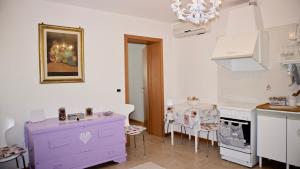 a kitchen with purple cabinets and a table with chairs at Appartamento Ca' Di Nive in Venice