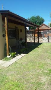 een huis met een overdekte veranda en een grasveld bij Alojamiento Doña Zule in San José