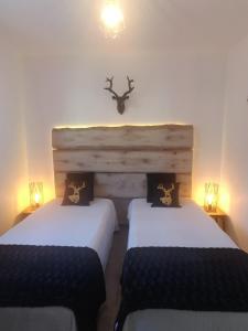 two beds in a room with two lights on the wall at MAISON FAMILIALE 3 ch. au CENTRE D'AX in Ax-les-Thermes